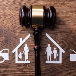  A gavel on a table separating a paper cutout of a family