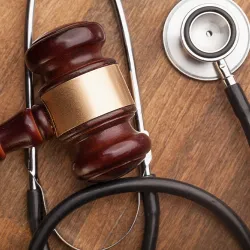 A gavel and stethoscope laying on a table